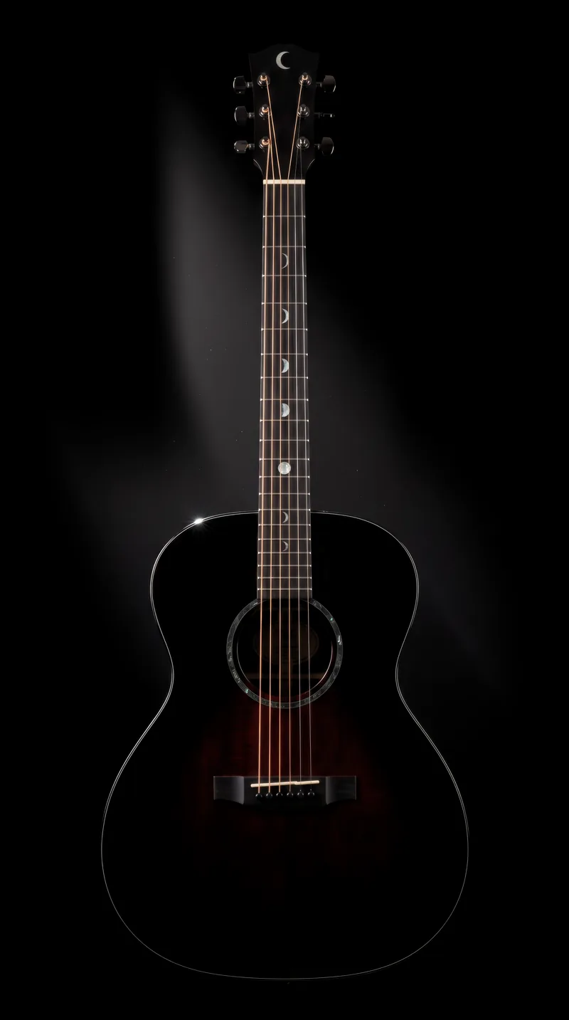 A jet-black orchestra-model guitar with an oxblood glow at its centre and a black abalone rosette, standing upright against pure black under one hard light, pearl moon phases running up the fingerboard from a thin crescent to a full moon.